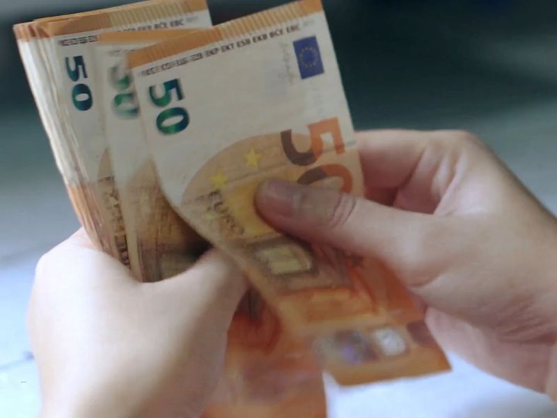 čovek drži i broji novčanice od 50evra